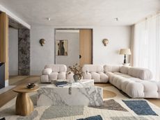 A living room with an organic-shaped coffee table in marble
