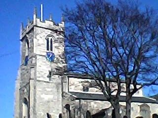 Low-res photo of a statue of an English church under a blue sky