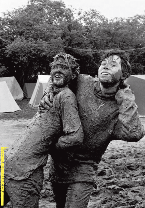 Two people play in the mud at Glastonbury in the 1980s
