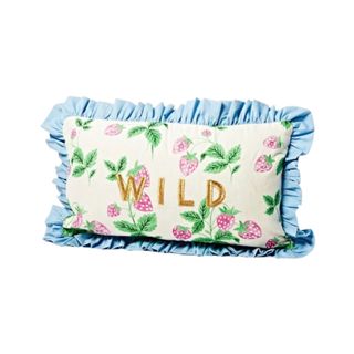 A strawberry patterned cushion that says 'wild'