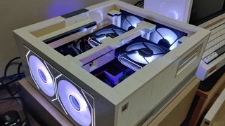 Custom LEGO PC built in a retro-style beige case resembling a 1990s desktop, featuring illuminated cooling fans and modern components inside.