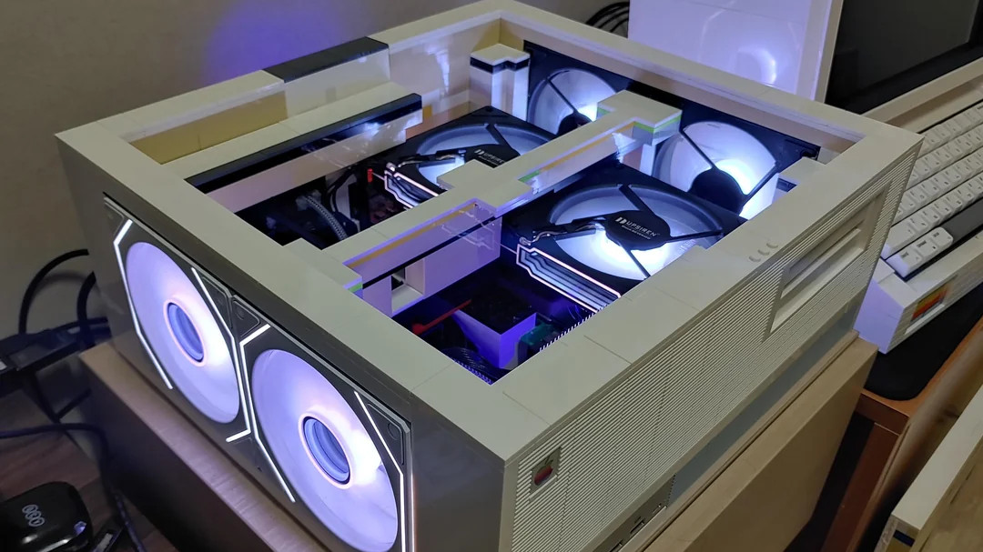 Custom LEGO PC built in a retro-style beige case resembling a 1990s desktop, featuring illuminated cooling fans and modern components inside.