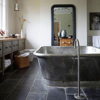 bathroom with wash basin bath and tap and slate floor tiles