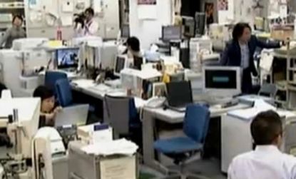 Office workers brace themselves during the second earthquake (this one a 7.1 magnitude) to hit north east japan in less than a month.