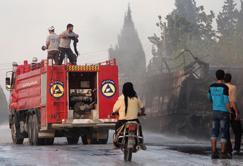 Syrian civil defense forces try to extinguish fire from bombed aid truck