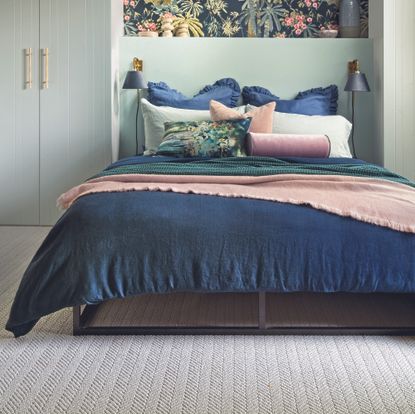 green and navy bedroom with a neutral carpet flooring