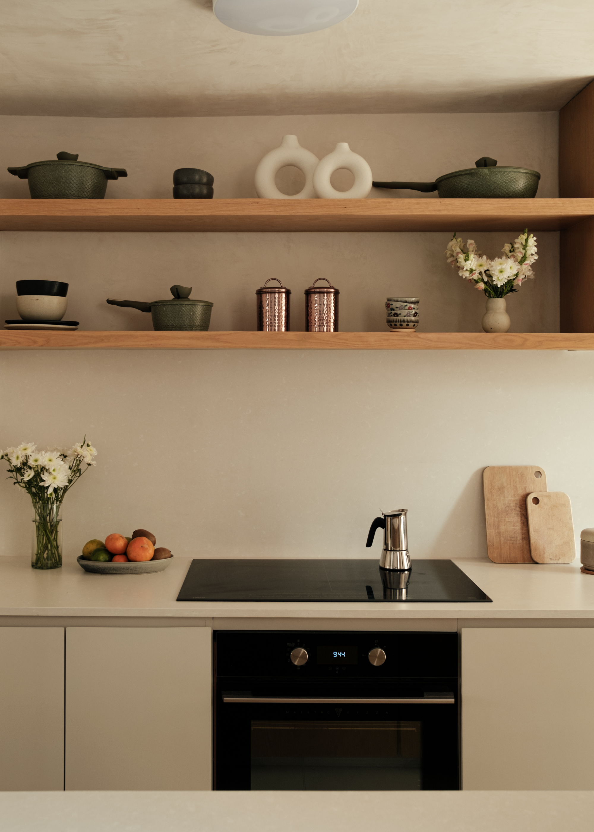 sleek modern cashmere kitchen with induction hob and open shelving with kitchen accessories