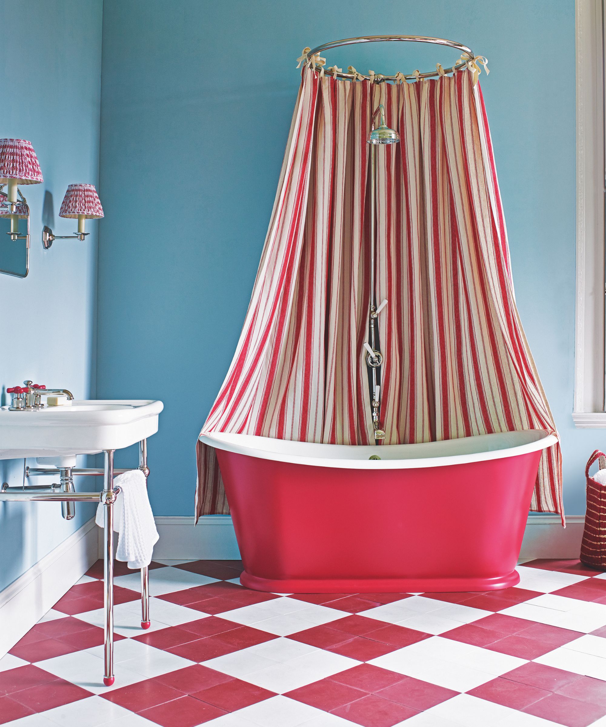 Bathroom with blue walls, red striped shower curtain, red bathtub, and red diamond tiles