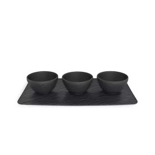 three black dipping bowls on black plate