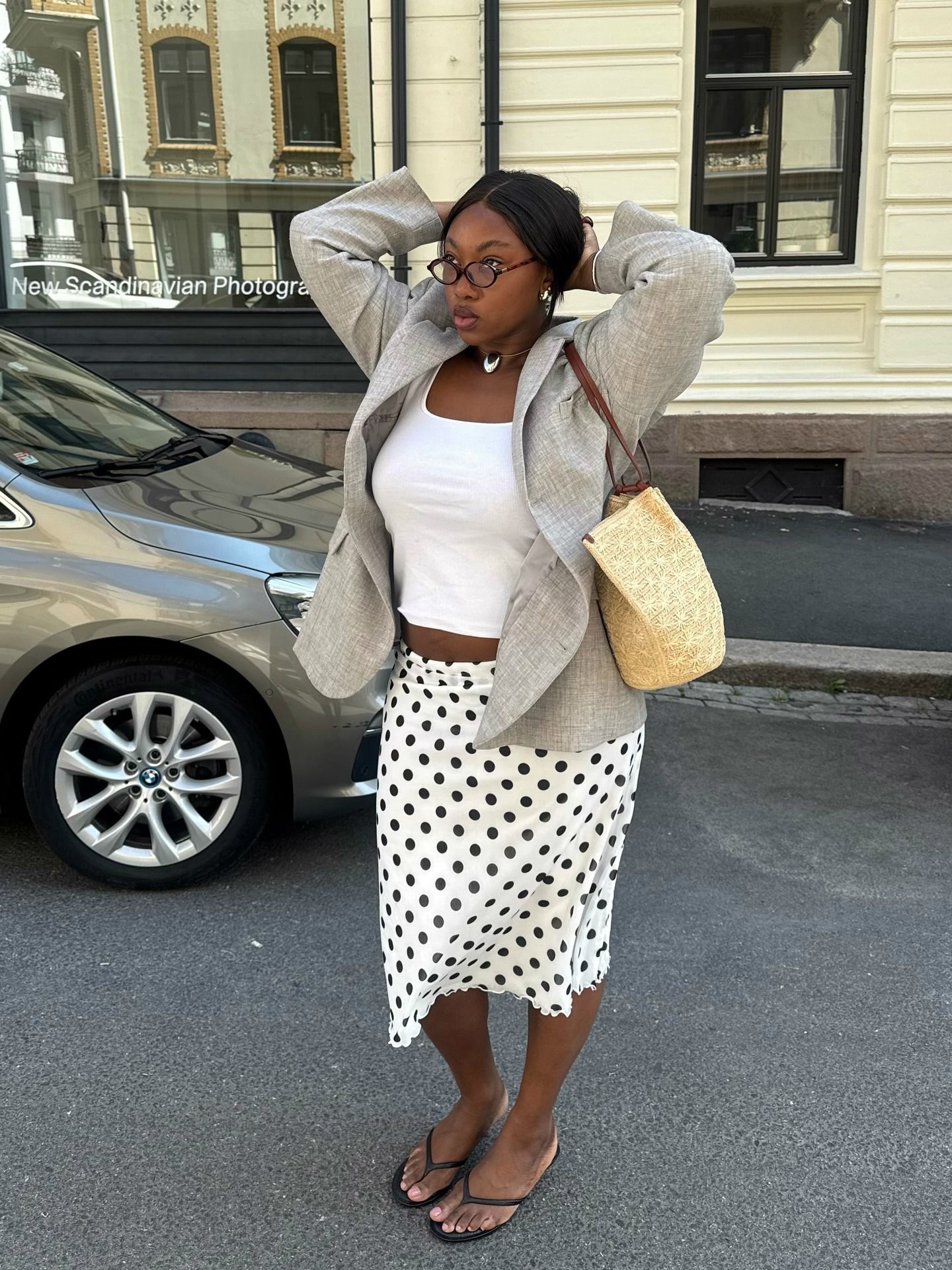 Woman in polka-dot skirt and white tank top.