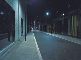 Photo of city street at night lit with street lights.