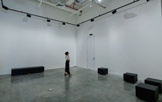 A person walks around the art space as d&b Soundscape speakers are strategically placed.