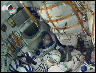 Astronaut Mike Hopkins sits in his seat aboard a Soyuz spacecraft before launching to the International Space Station. Image released Sept. 25, 2013.