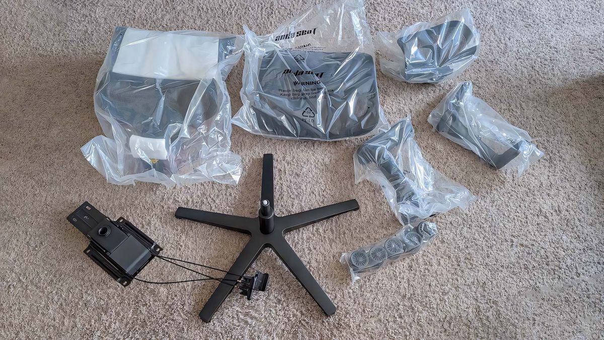 All parts of the AndaSeat X-Air Pro Mesh Office Chair laid out on the floor before assembly.