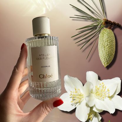 hannah baxter's hand holding a glass perfume bottle with flowers