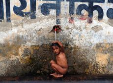 A child cools off under a tap in Allahabad
