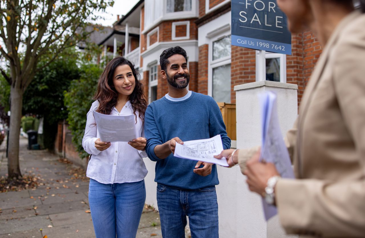 Two first time buyers getting the documents for their new home