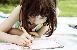 Little girl writing a letter