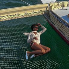 Content creator Destiny Joseph lying on a net aboard a boat.