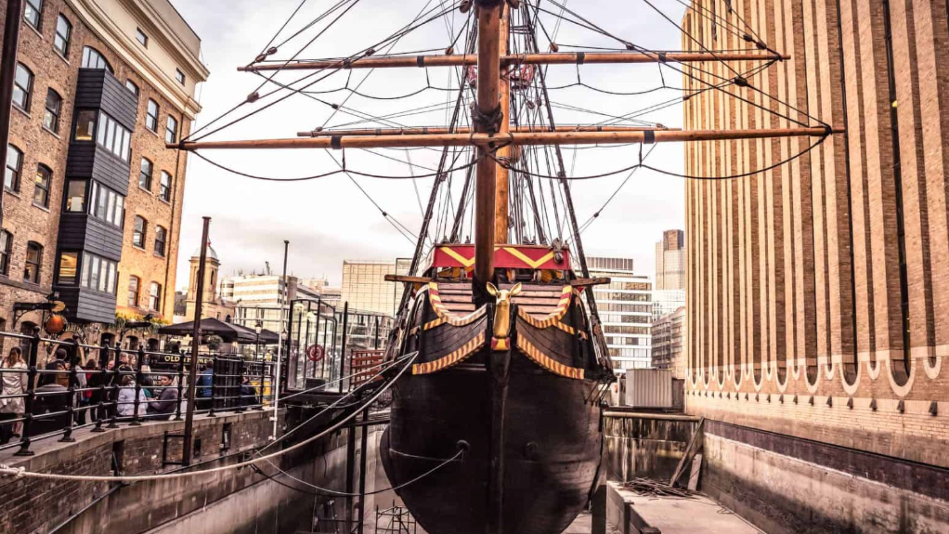 an image of the ship taken head on showing its prow, bow, and the front part of the main deck in a dry dock on London's Thames bank