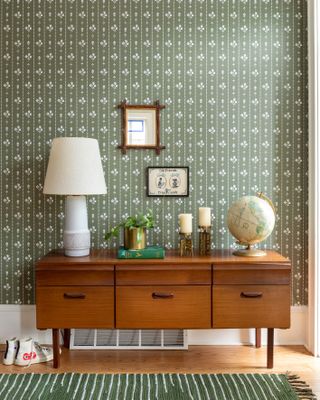 mid century sideboard against wallpapered wall