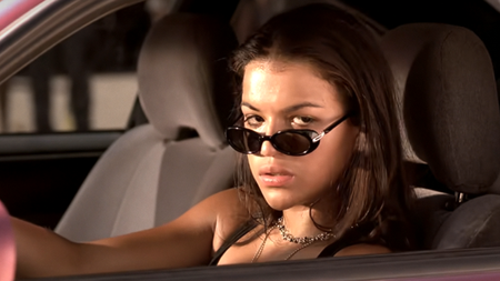 Michelle Rodriguez as Letty with her sunglasses down her nose while in the driver's seat 