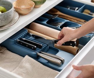 A deep blue knife organizer in a drawer