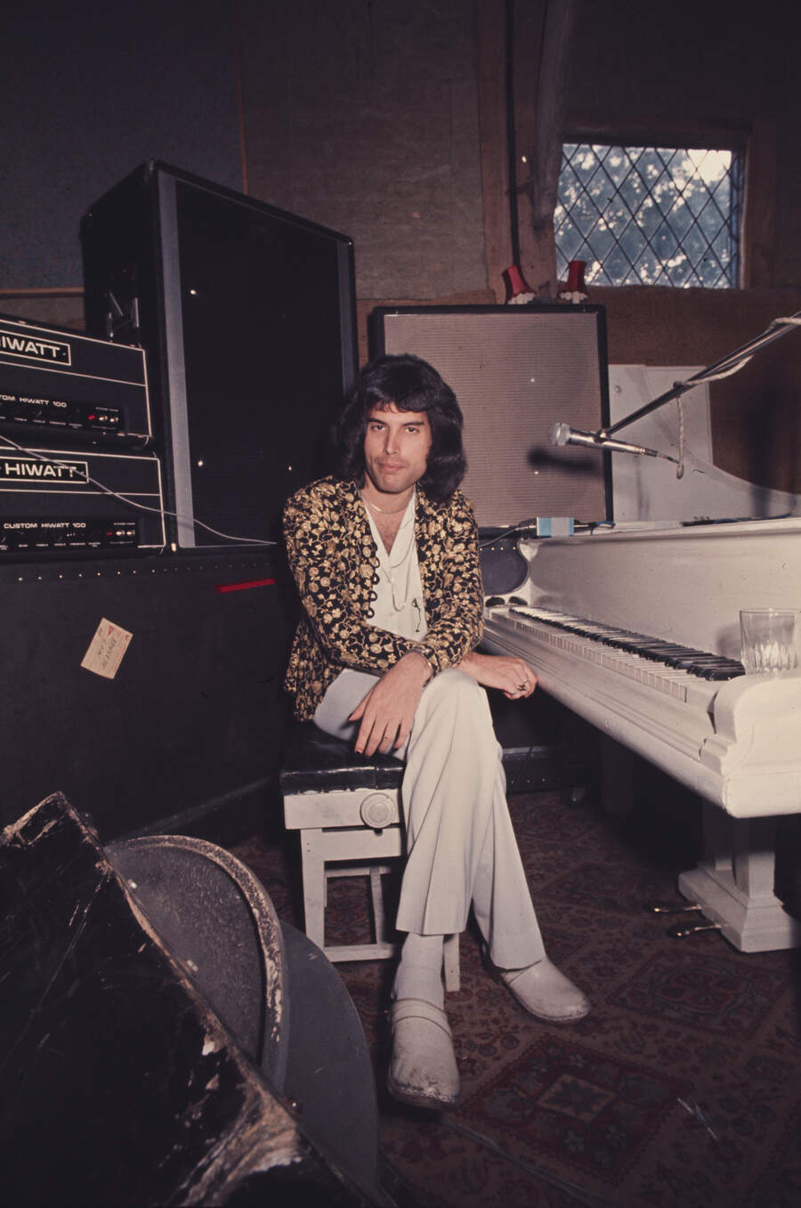 Freddie Mercury of Queen sitting at a white grand piano at Ridge Farm Studio during the recording of their album &#039;A Night At The Opera&#039;, Surrey, United Kingdom, 14th July 1975.