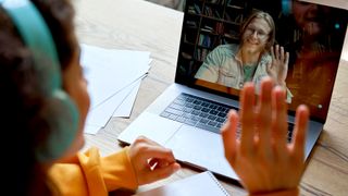 Two people waving to each other on a video call