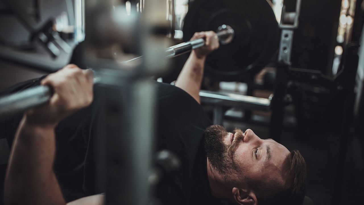 One man, weightlifting training on bench press in gym