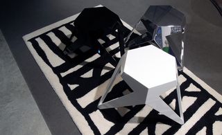 View of three stools in black, white and blue silver colours by Hannes Wettstein and the 'Écritures Rug' by Christian Astuguevieille which is black and off-white coloured