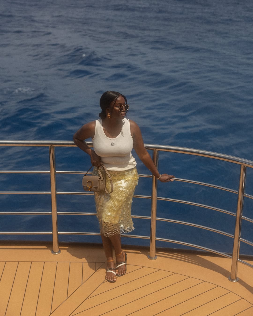 @cocobassey wearing a sequin skirt, white tank and sandals