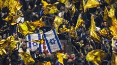 Maccabi supporters wave yellow flags next to Israeli flags during the UEFA Europa League football match between Ajax Amsterdam and Maccabi Tel Aviv at the Johan-Cruijff stadium, in Amsterdam on November 7, 2024