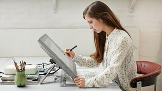 A graphic designer using the best graphic design software on a pen display