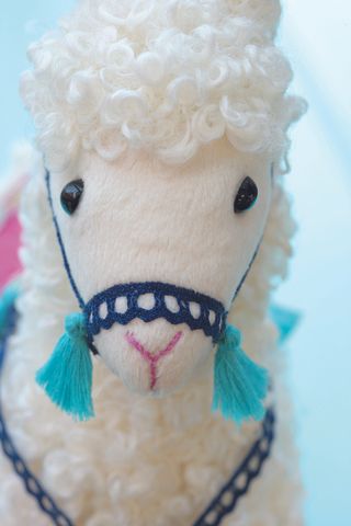 Attaching the bridle to the llama toy