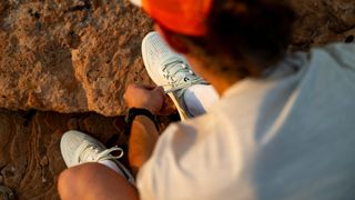 A model lacing up a Scott Ultra Explore trail running shoe
