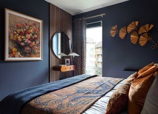 blue bedroom with round mirror