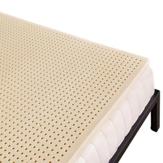 A beige twin mattress topper on a black bed frame