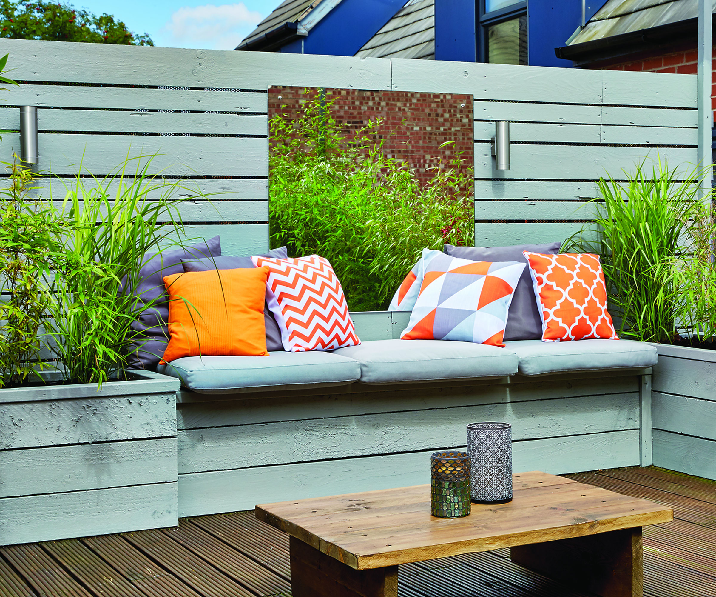 patio with duck egg blue fence, garden bench and planters, garden table and cushions