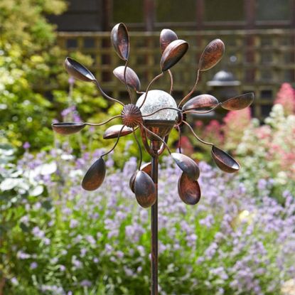 Gemini Wind Spinner with Solar Crackle Globe in a thriving garden during the day