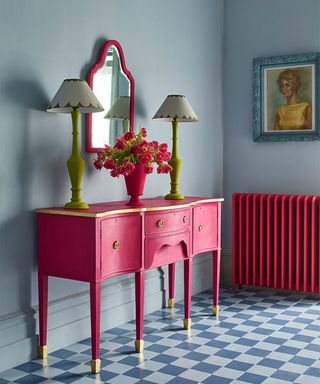 grey hallway with checked floor and bright pink console table and mirror