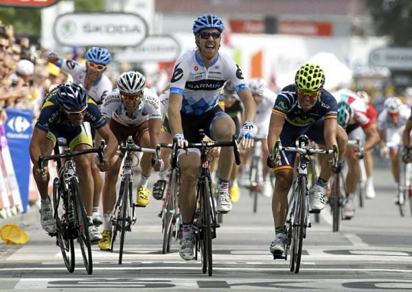 Garmin-Cervelo's Tyler Farrar raises his arms in victory as teammate Julian Dean celebrates behind.
