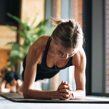 A woman training for strength vs hypertrophy holding a plank