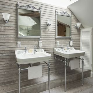 room with mirror on wooden wall and white washbasin