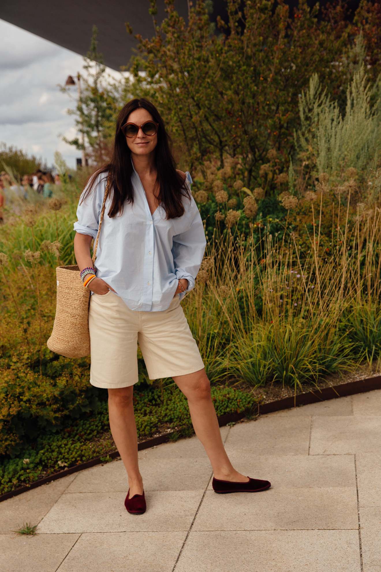 A copenhagen spring 2025 fashion week attendee wears a button down, bermuda shorts, and flats