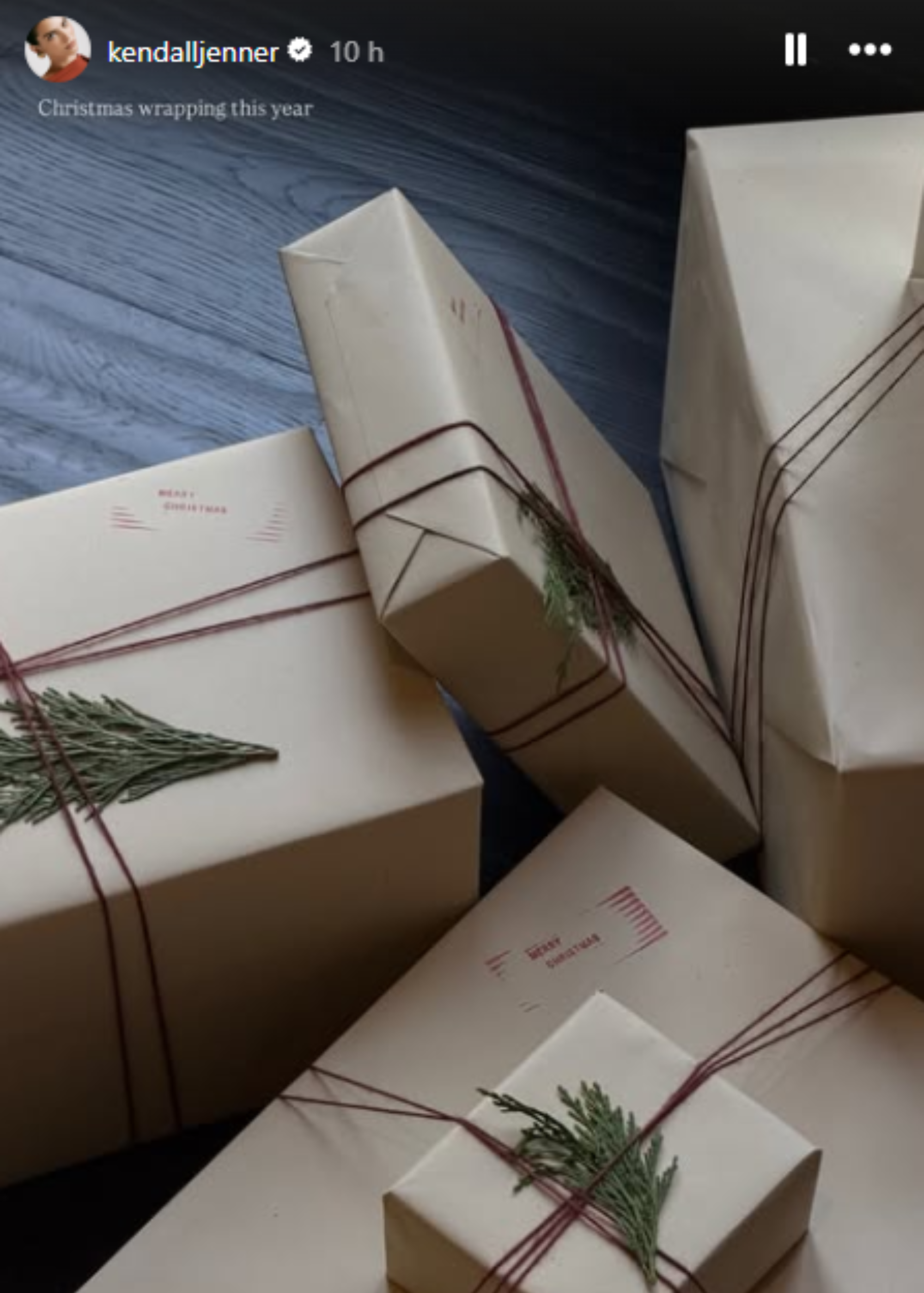 A bunch of presents wrapped in brown paper, with red string, and a sprig