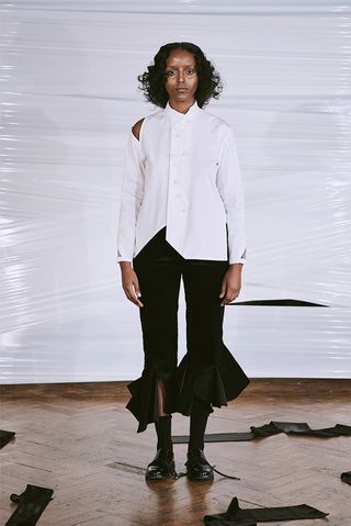 Model wears a white cut out shirt and balloon leg trousers