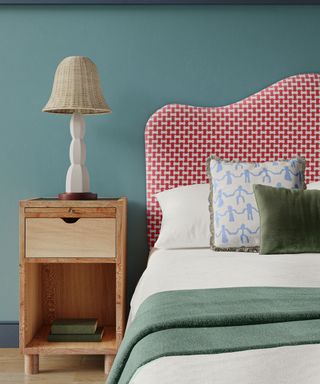 Bedroom with blue walls, red headboard and woven lampshade