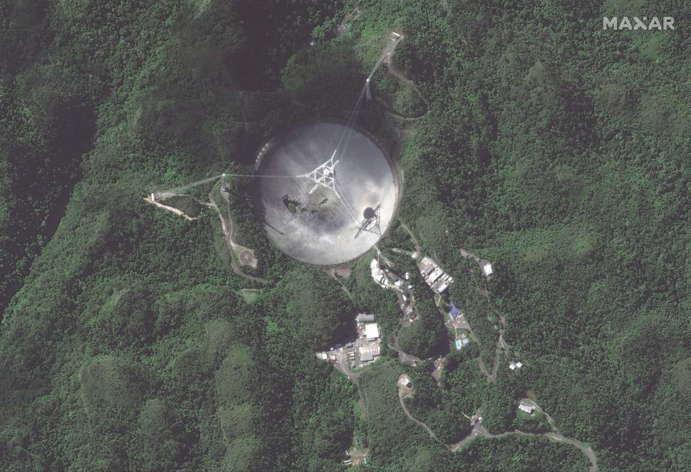 Arecibo radio telescope, damaged beyond repair, seen from space
