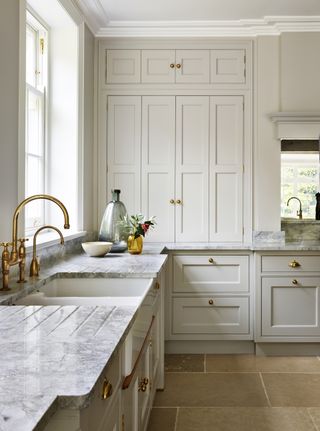 cream shaker kitchen with built in cabientry and marble worktops